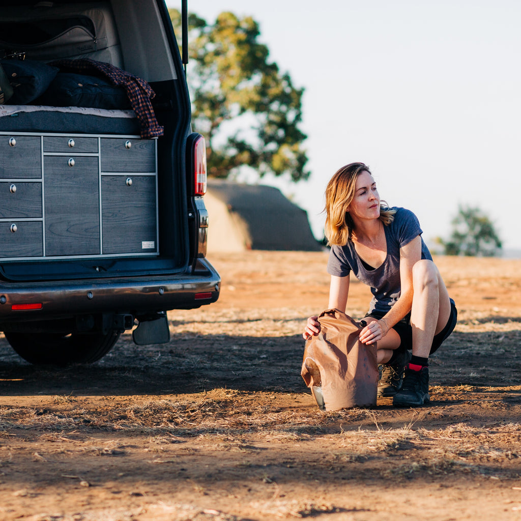 Woman using Tactical bag next to vehicle