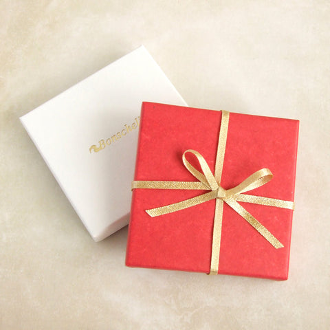 Bonschelle gift wrapped box with red tissue and gold bow