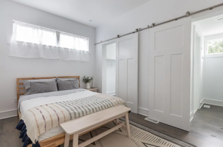 A minimal, modern bedroom with white walls and a double bed