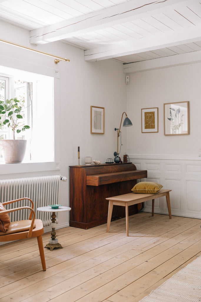 A minimal room decorated in the Scandinavian style, with a wooden piano and bench