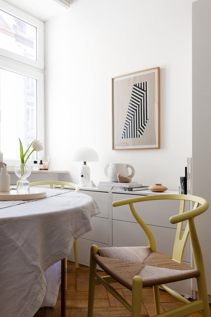 A bright, white-walled kitchen space with wooden floorboards