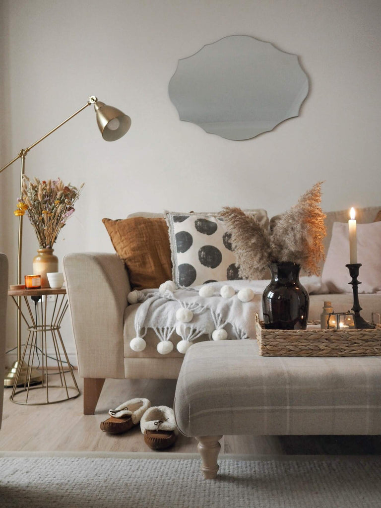 A cozy, light lounge with a decorative lamp and candle