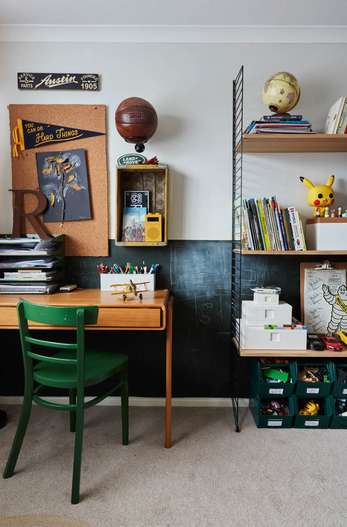 A colorfully-decorated children's room with desk and shelves