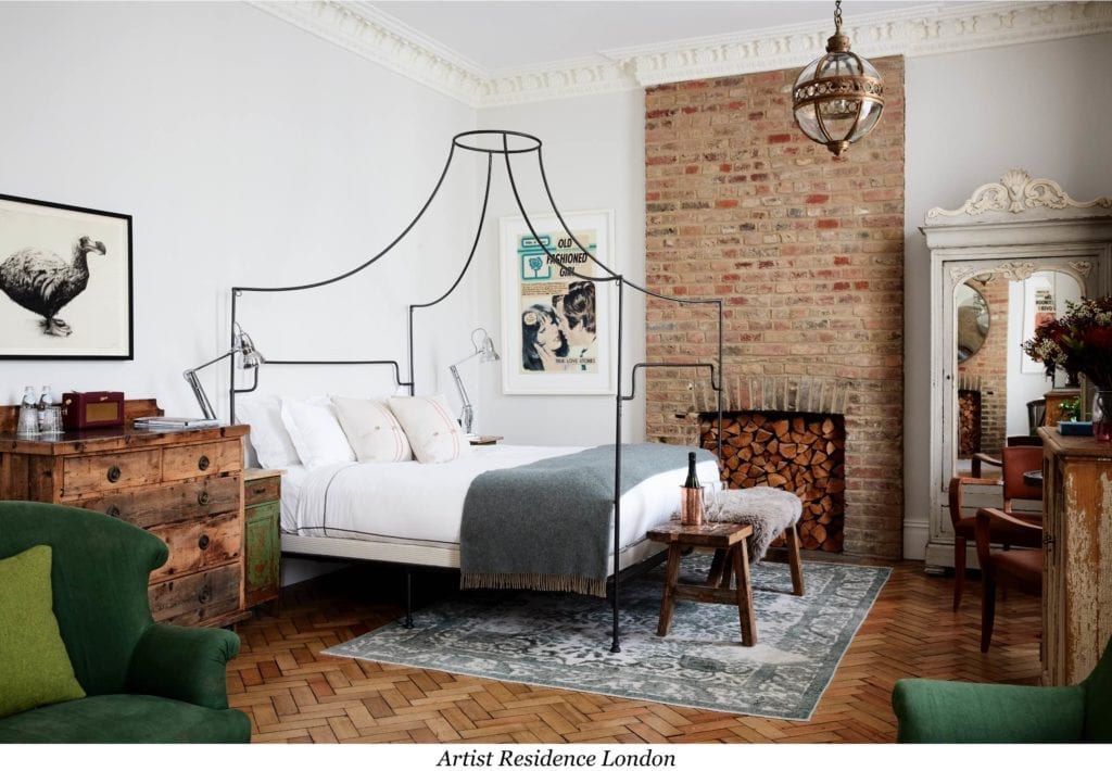 A bedroom with wooden floor, double bed, and exposed brickwork alcove