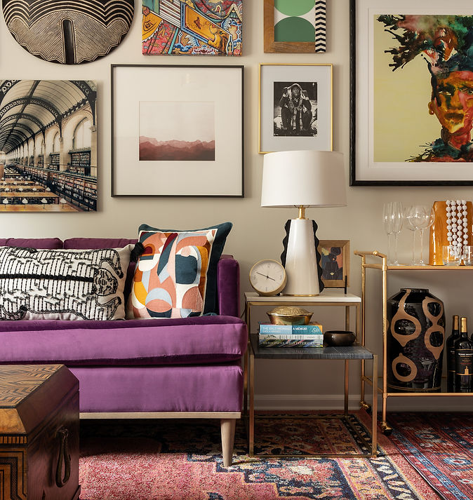 A lounge space decorated with a patterned rug, soda, and plenty of vibrant wall art.