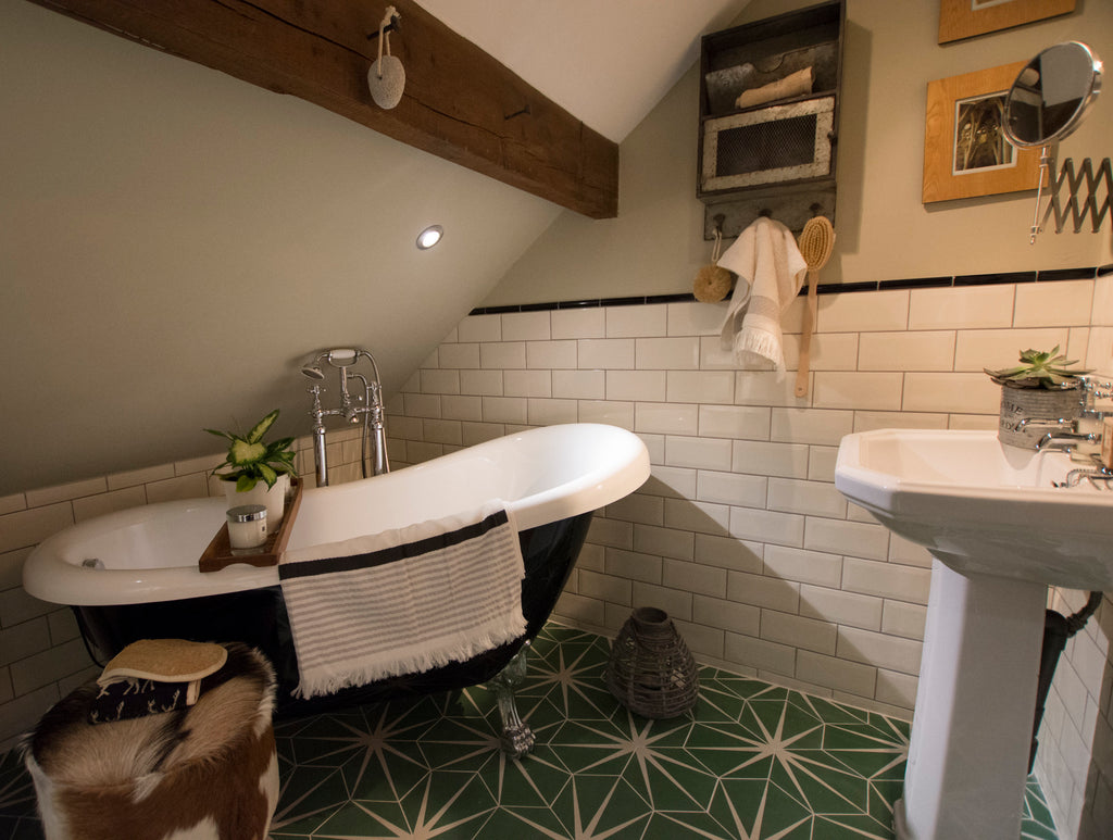 A loft converted into a bathroom, with bathtub, sink, and tiled walls