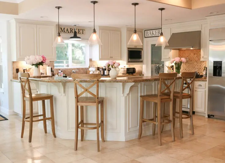 A large kitchen with a kitchen island, ceiling pendant lights, and wooden chairs