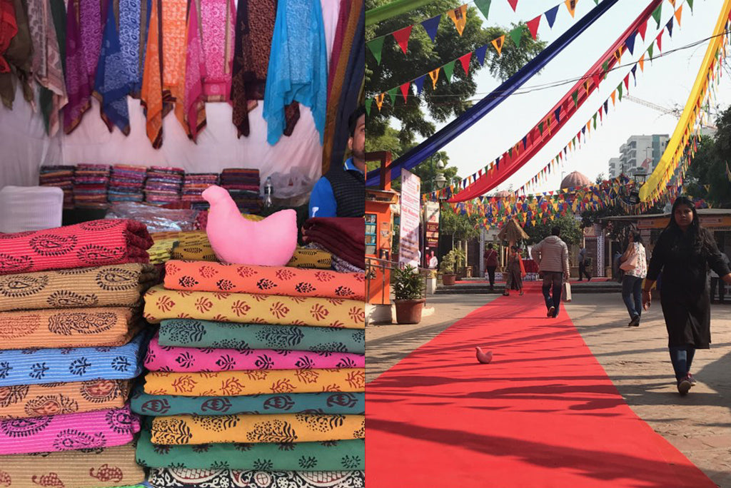 A stack of colorful textile in an India market with a stuffed Pink Chicken doll