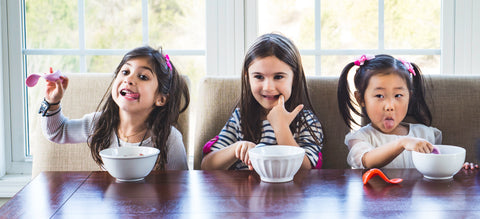 three girls eating at dinner table