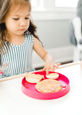 girl touching hard boiled egg on a plate