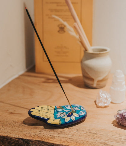 jalini incense holder hamsa on desk burning a stick of incense