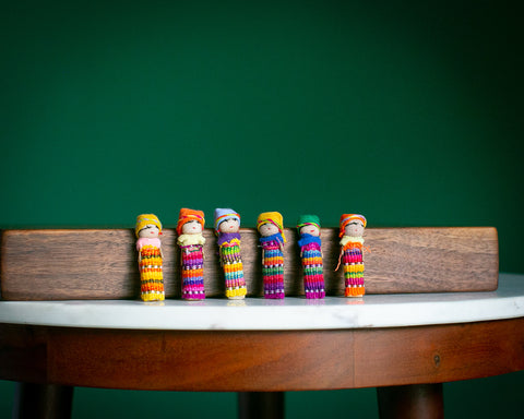 worry doll family on a table lined up in a row