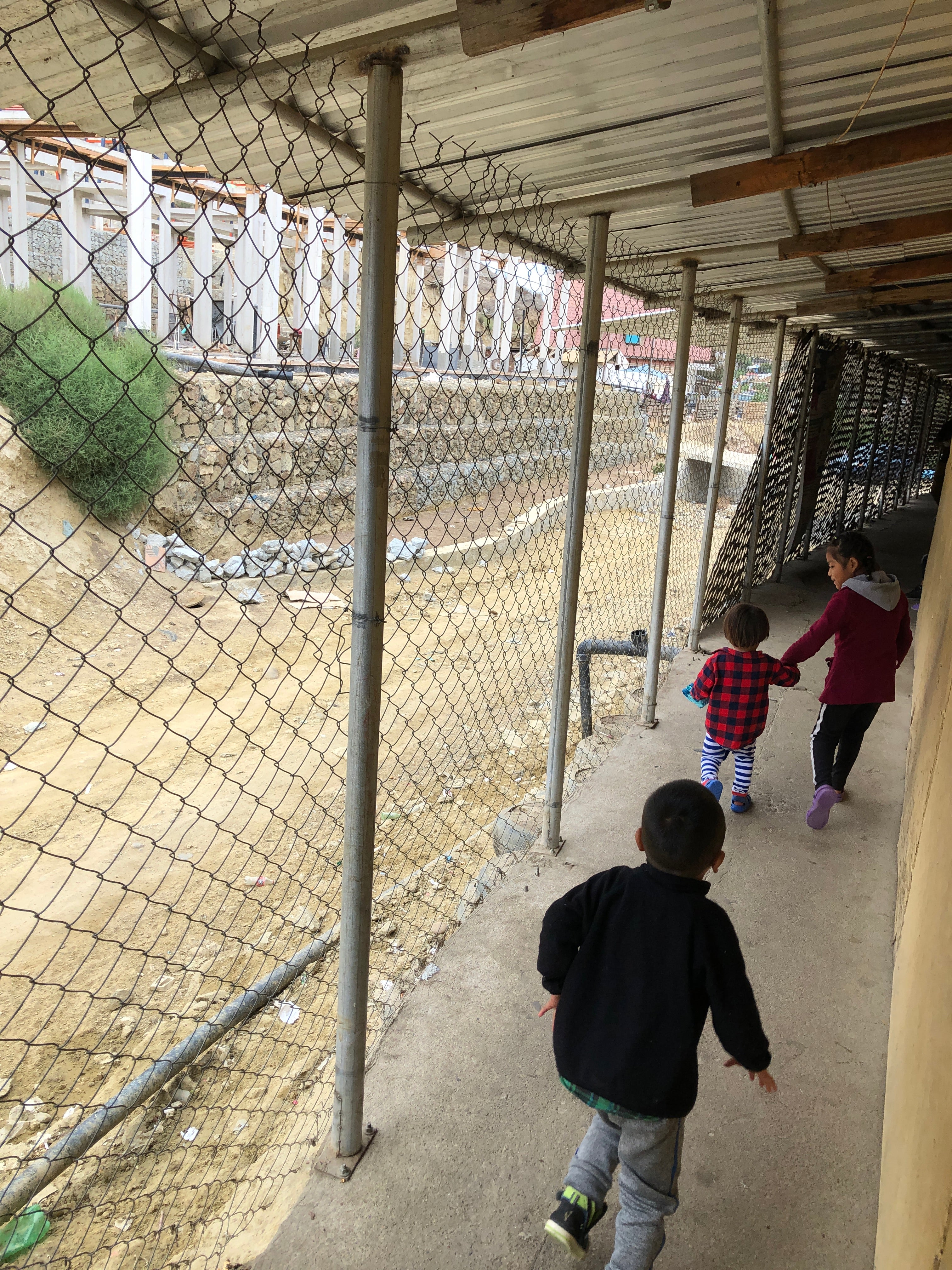 refugee camp kids near chain link fence sanctuary partnership do good shop