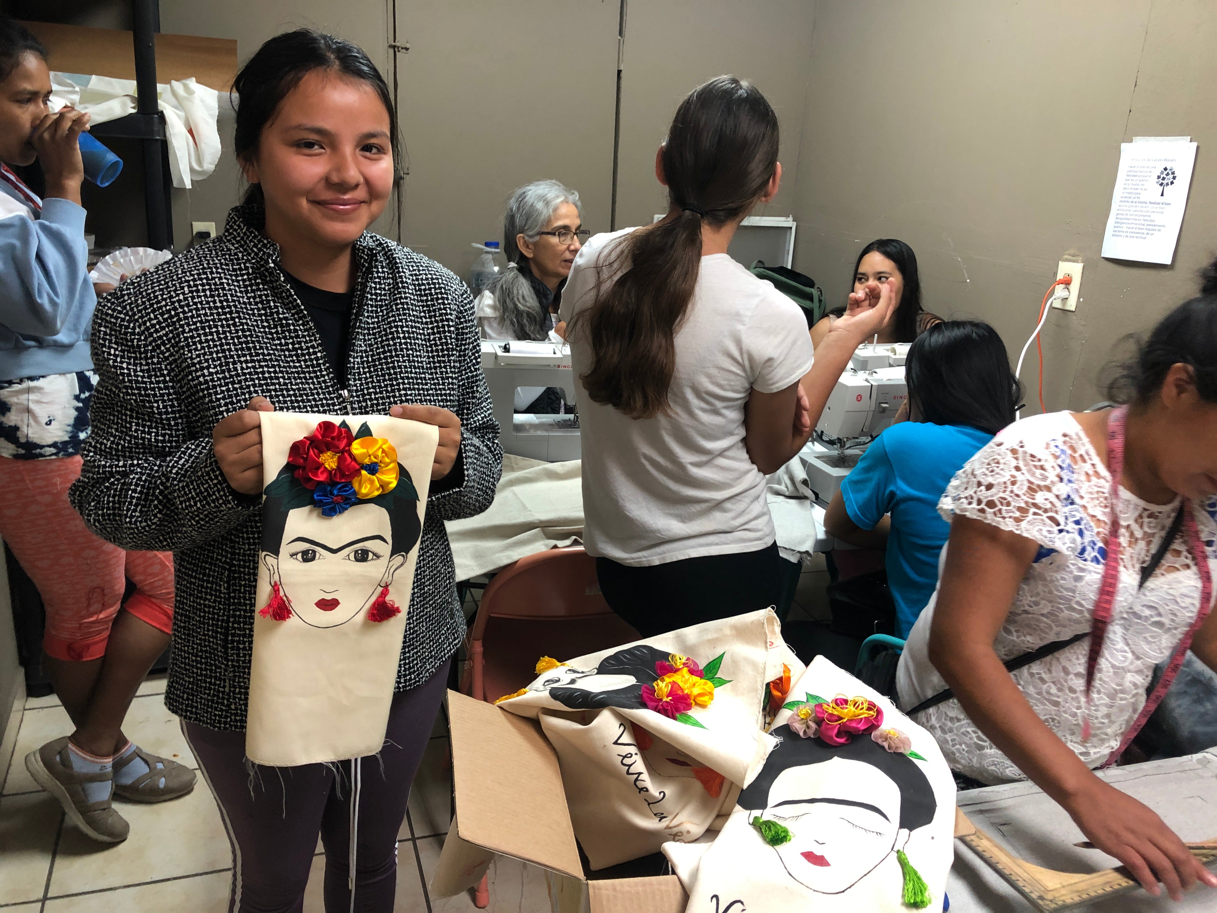 andrea holding frida kahlo art mexico sewing collective refugee sanctuary partnership do good shop