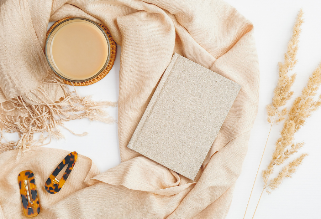 Journal laying flat with coffee and hair clips by it