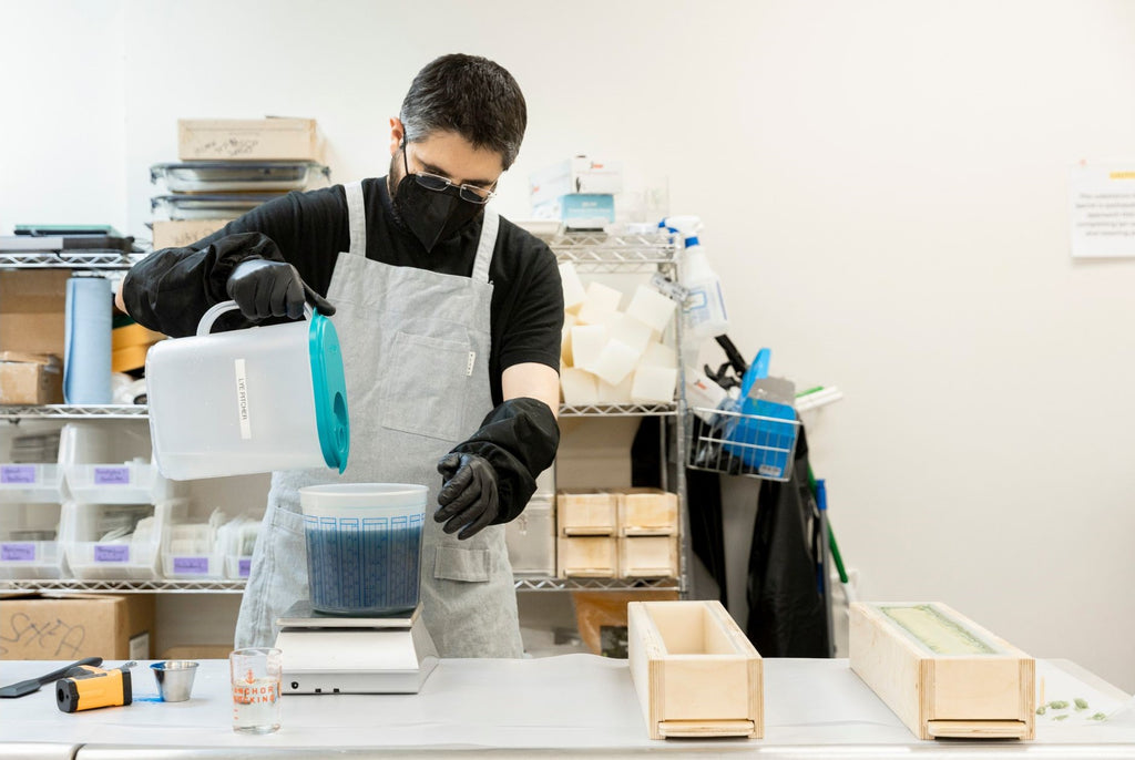 slow north team member works in the production studio with protective gear pouring lye to make natural bar soap