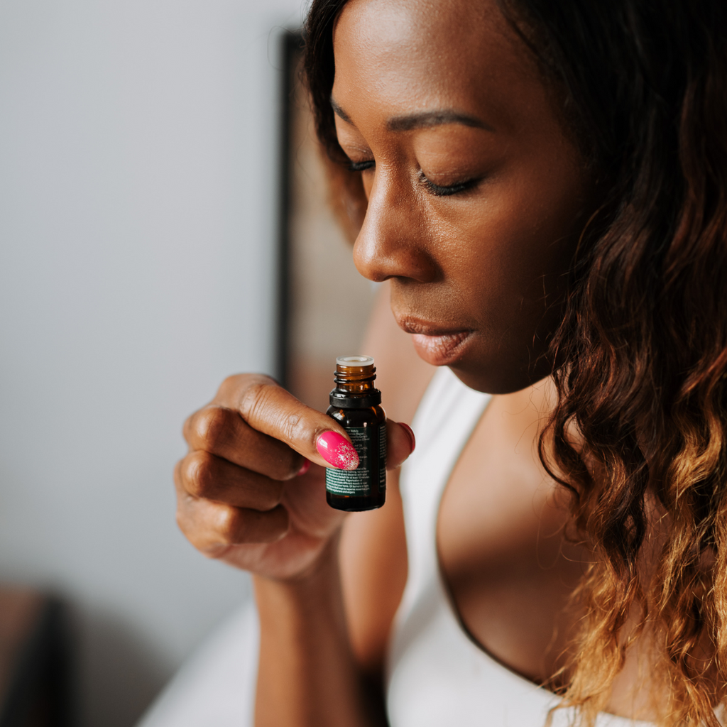 woman smelling essential oil blend
