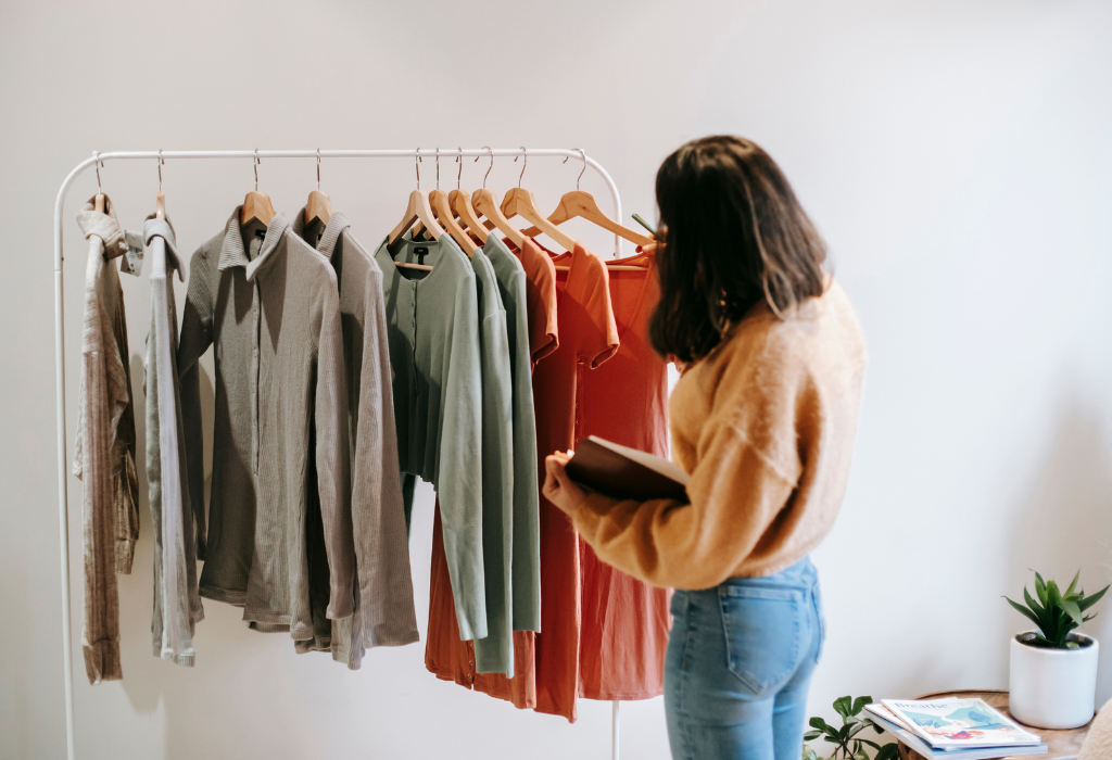 Young Woman picking clothing from a rack