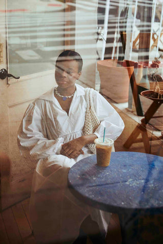 Dione sitting in a cafe wearing the HILLIER Dress in White