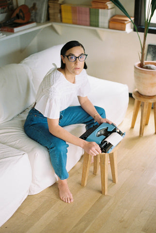 Mia Moretti sitting on her couch