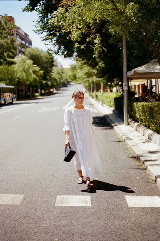 Clara walking down the street in the paradis dress in white