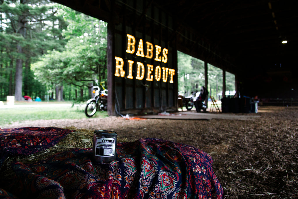 Shoppe 815 candle sitting on a hay bale in front of the Babes Ride Out sign on the East Coast