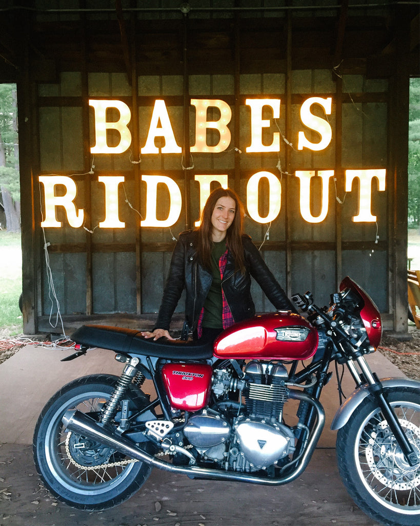 Katy with her Triumph Thruxton in front of the Babes Ride Out sign on the East Coast