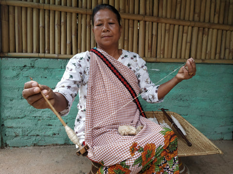 image shows an indian woman weaving silk