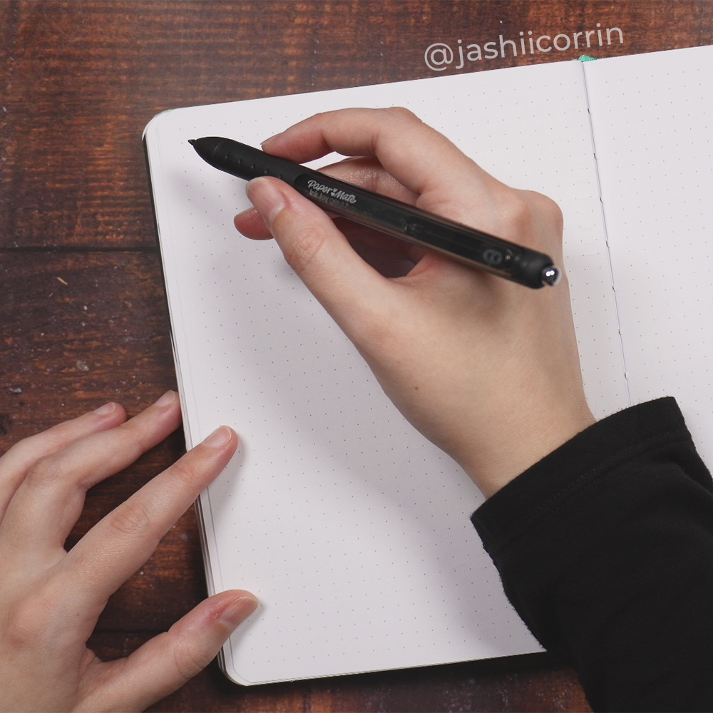 Hand with pen over blank notebook page