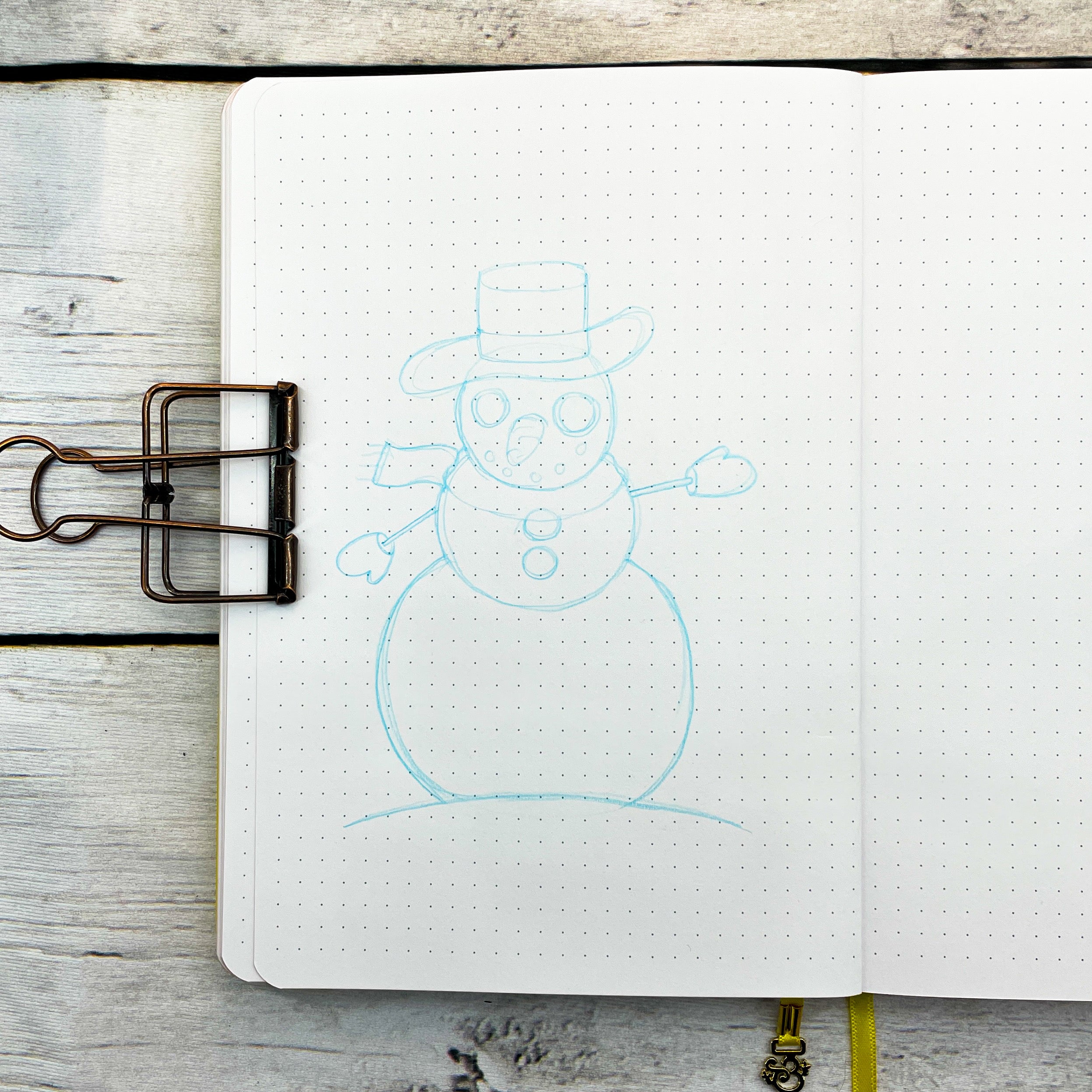 photo of a sketch of a snowman using blue lead