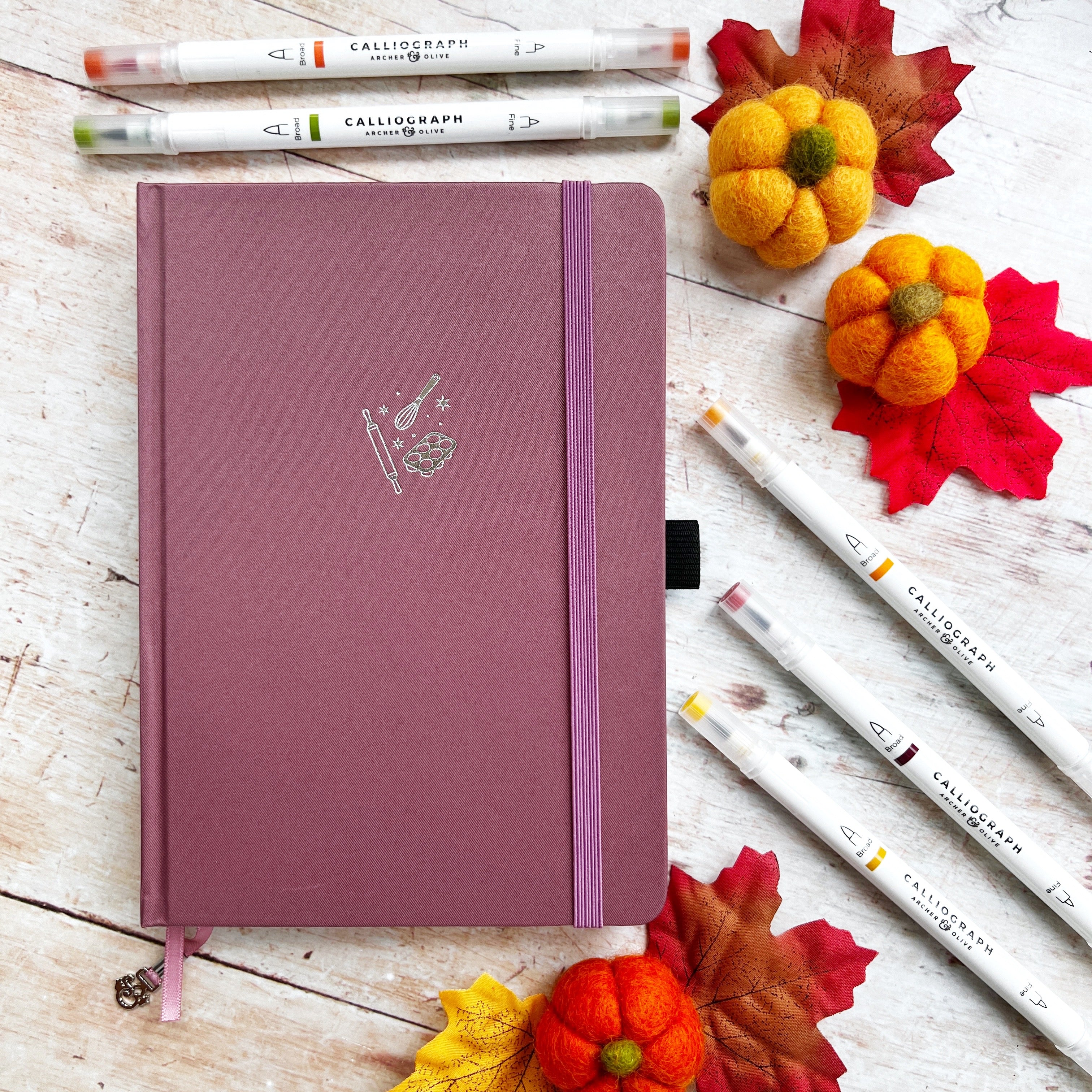 Dusky pink journal with whisk and pens