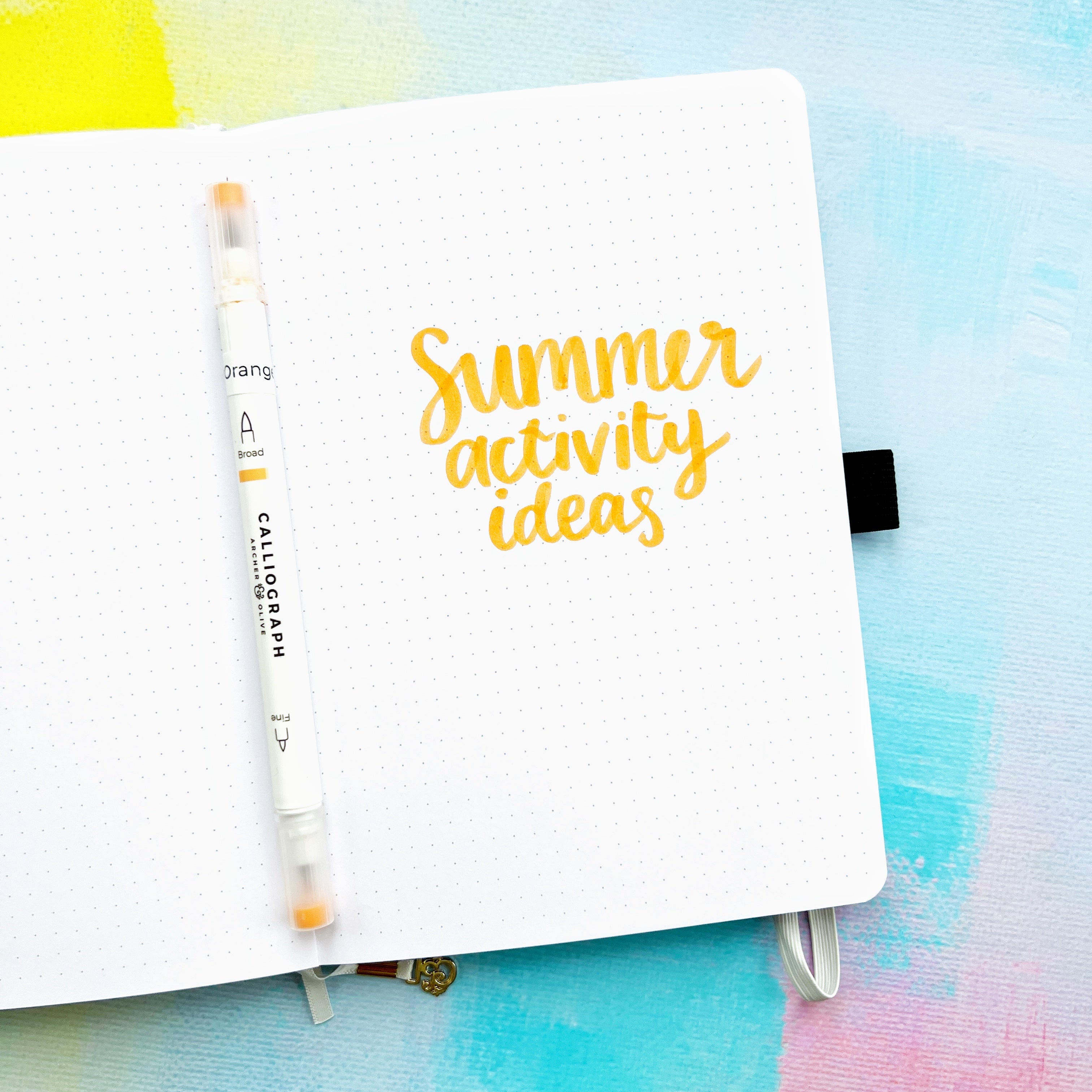 Summer Activity Ideas title on open journal page with orange brush pen