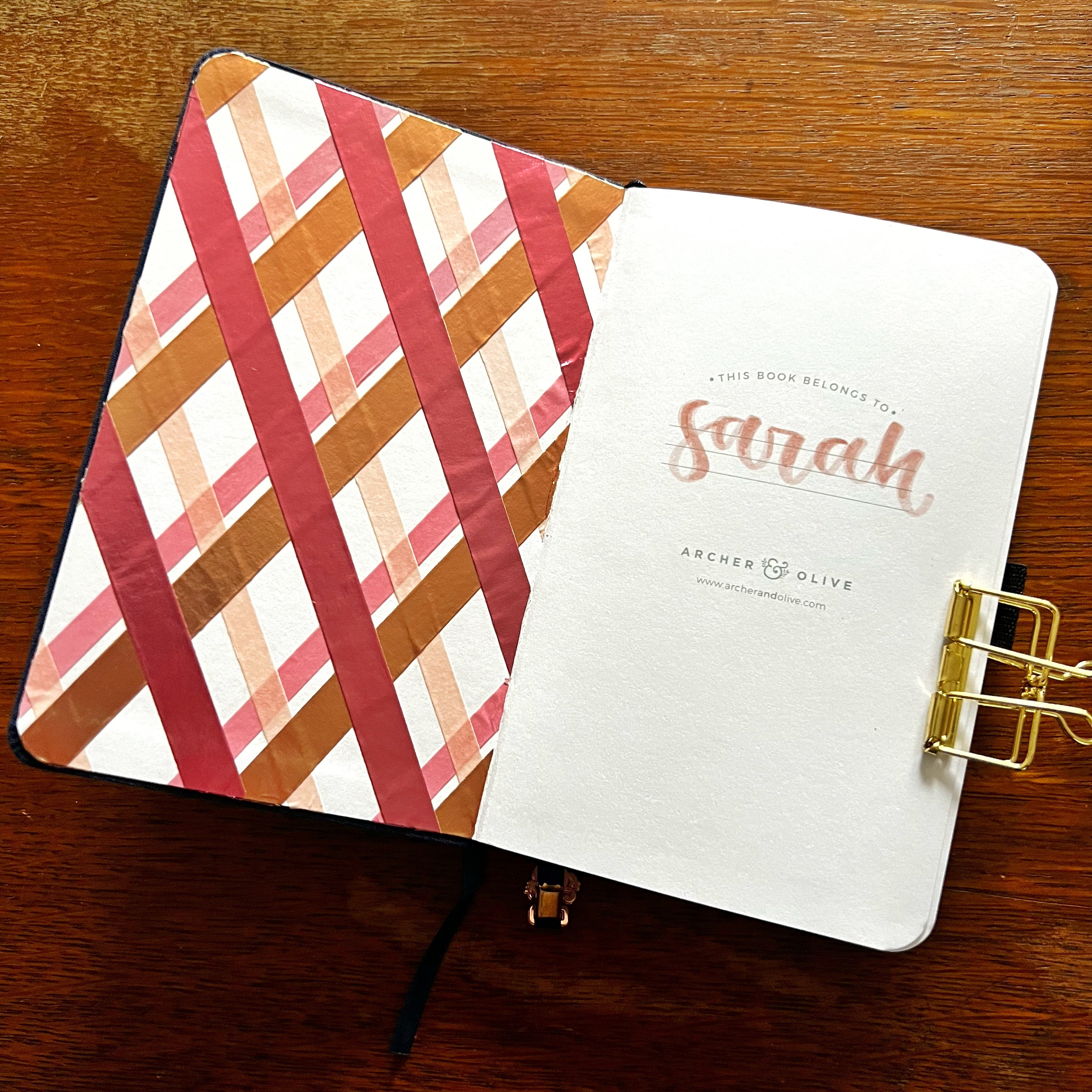 Notebook opened to inside cover decorated with an argyle pattern created with washi tape.