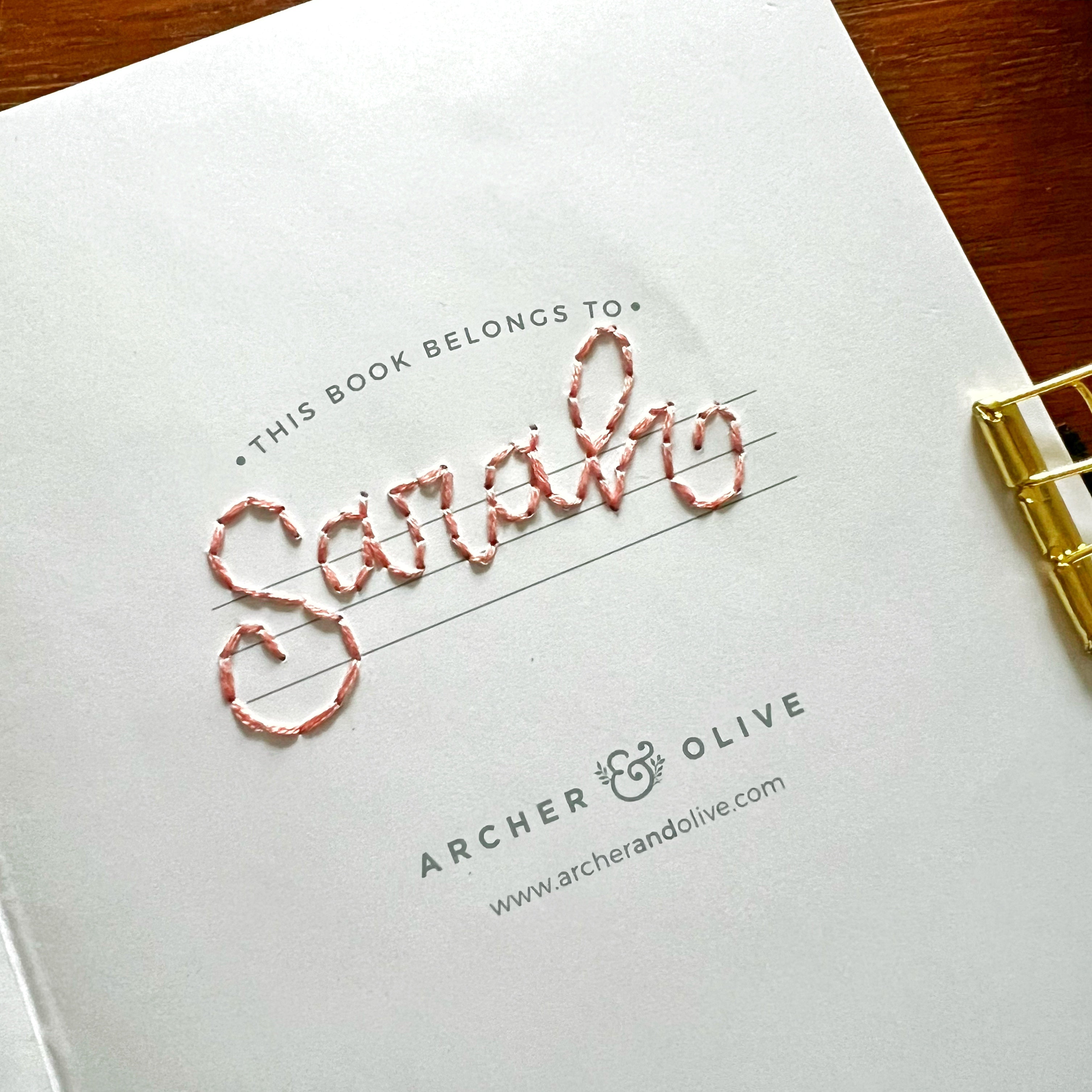 Inside cover of notebook with embroidered name “Sarah”