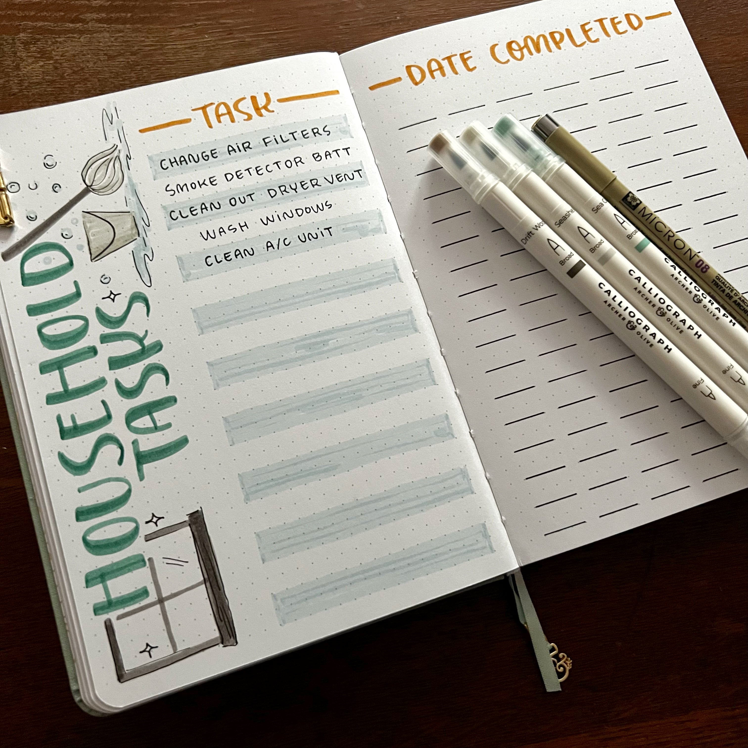 Open notebook featuring Household Tasks spread. Calliograph pens on the side of the notebook.