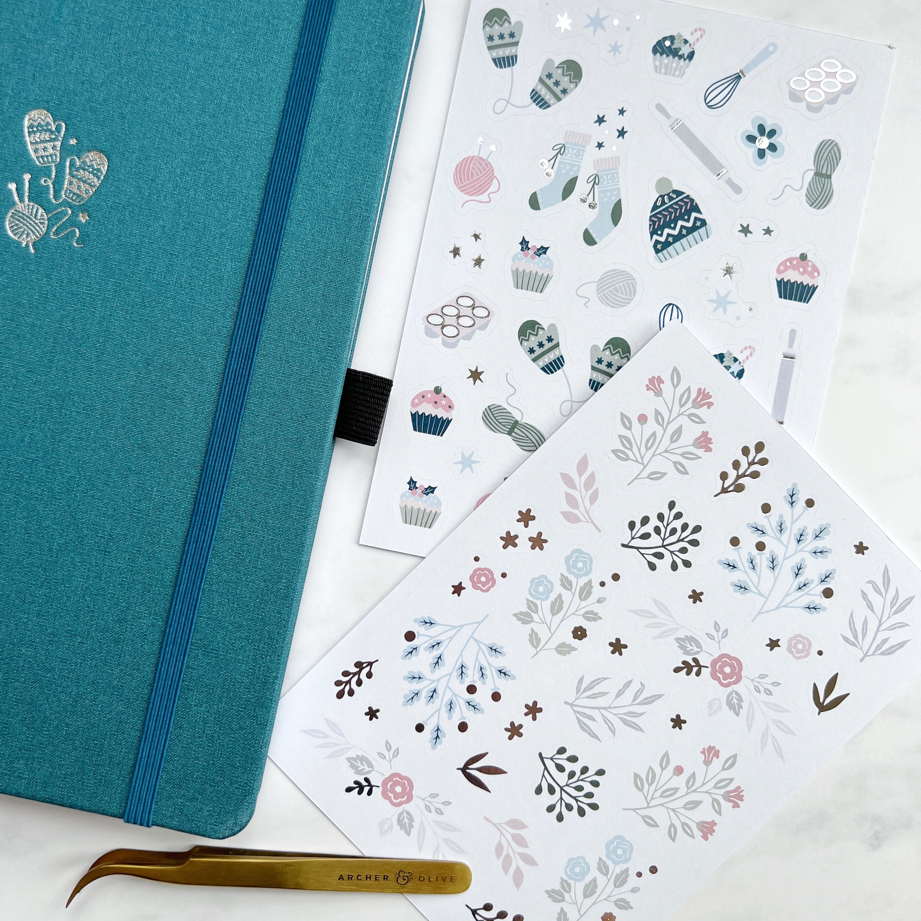 Winter themed stickers alongside teal journal