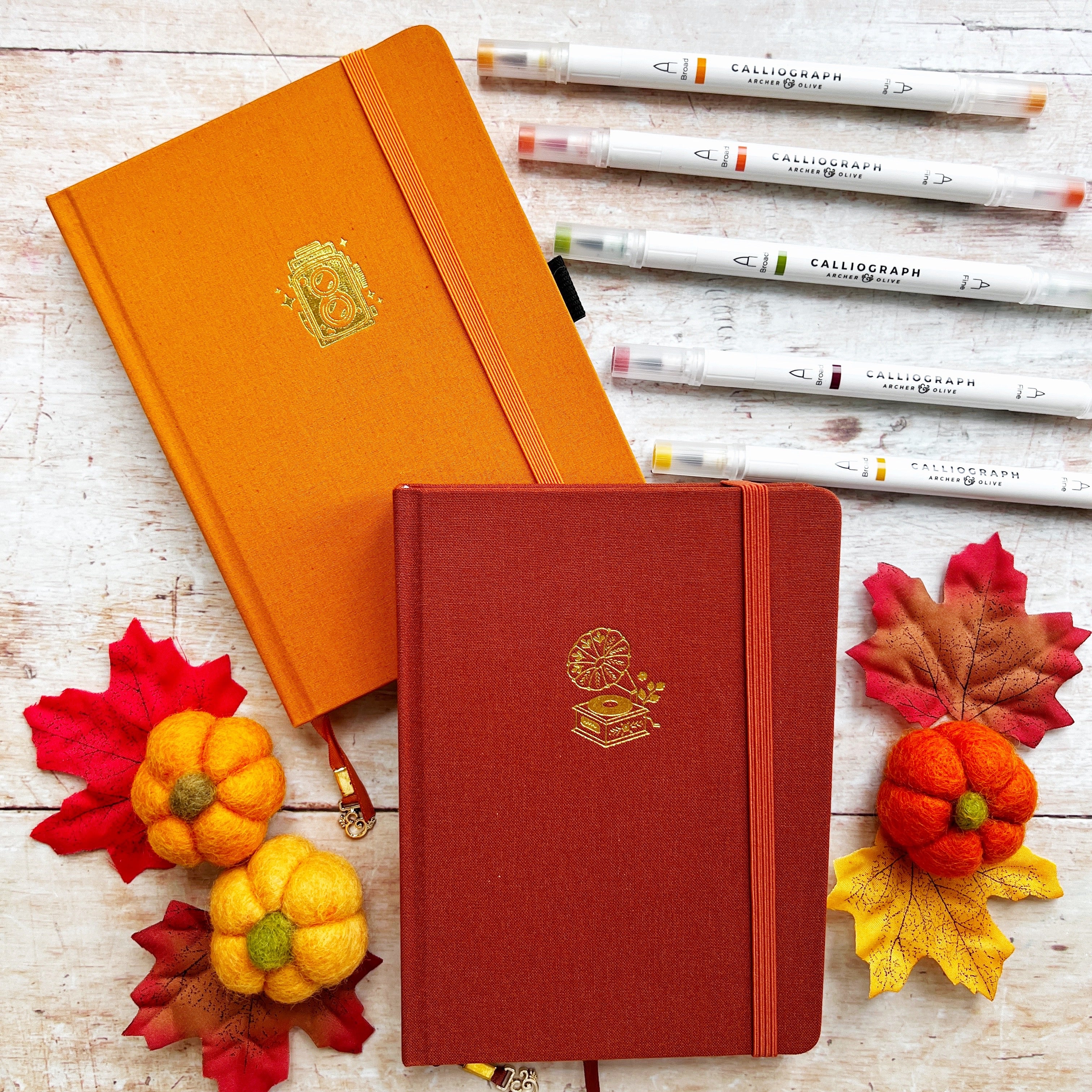 Orange and brown journals with pens