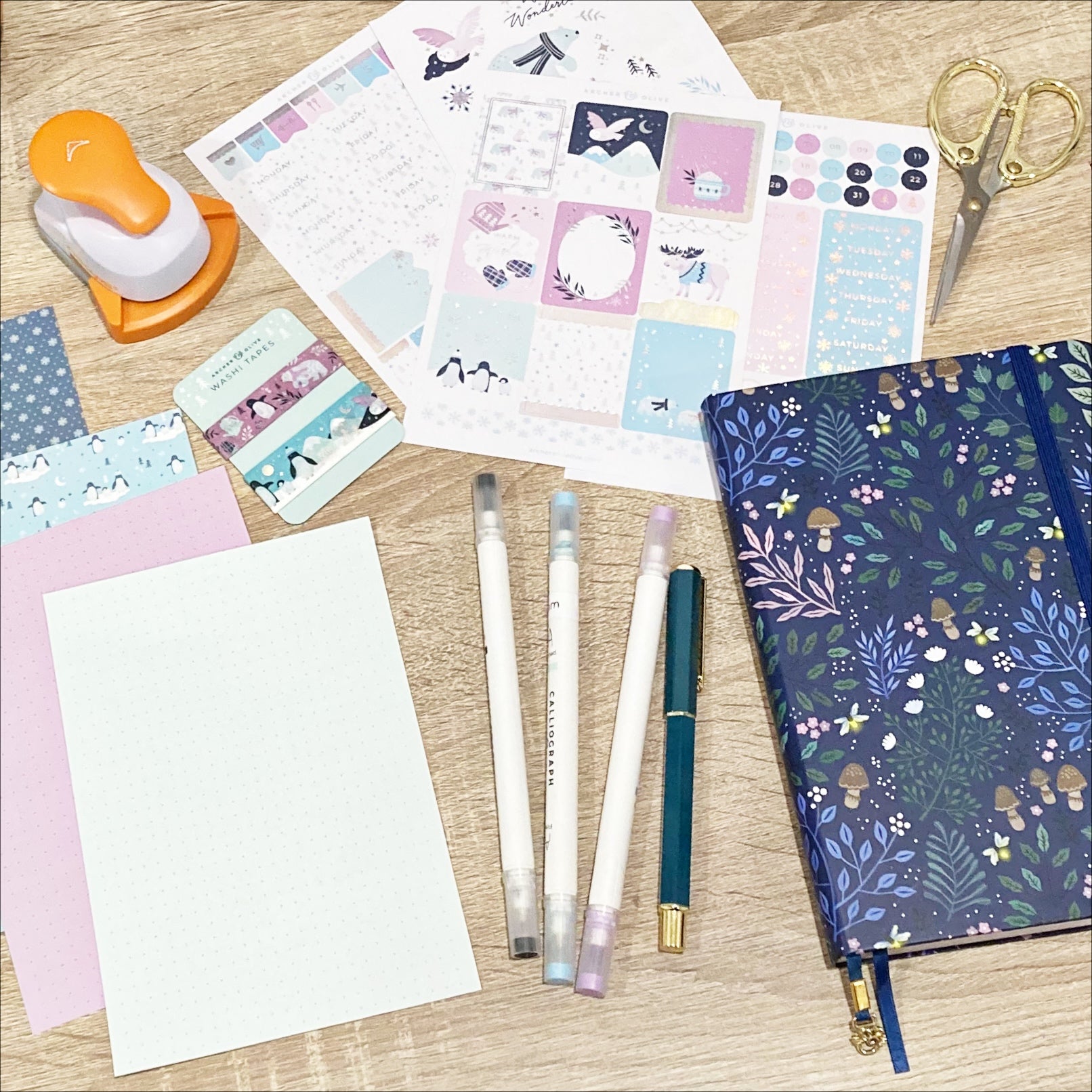 Paper, calliographs, stickers, washi, scissors, and a notebook