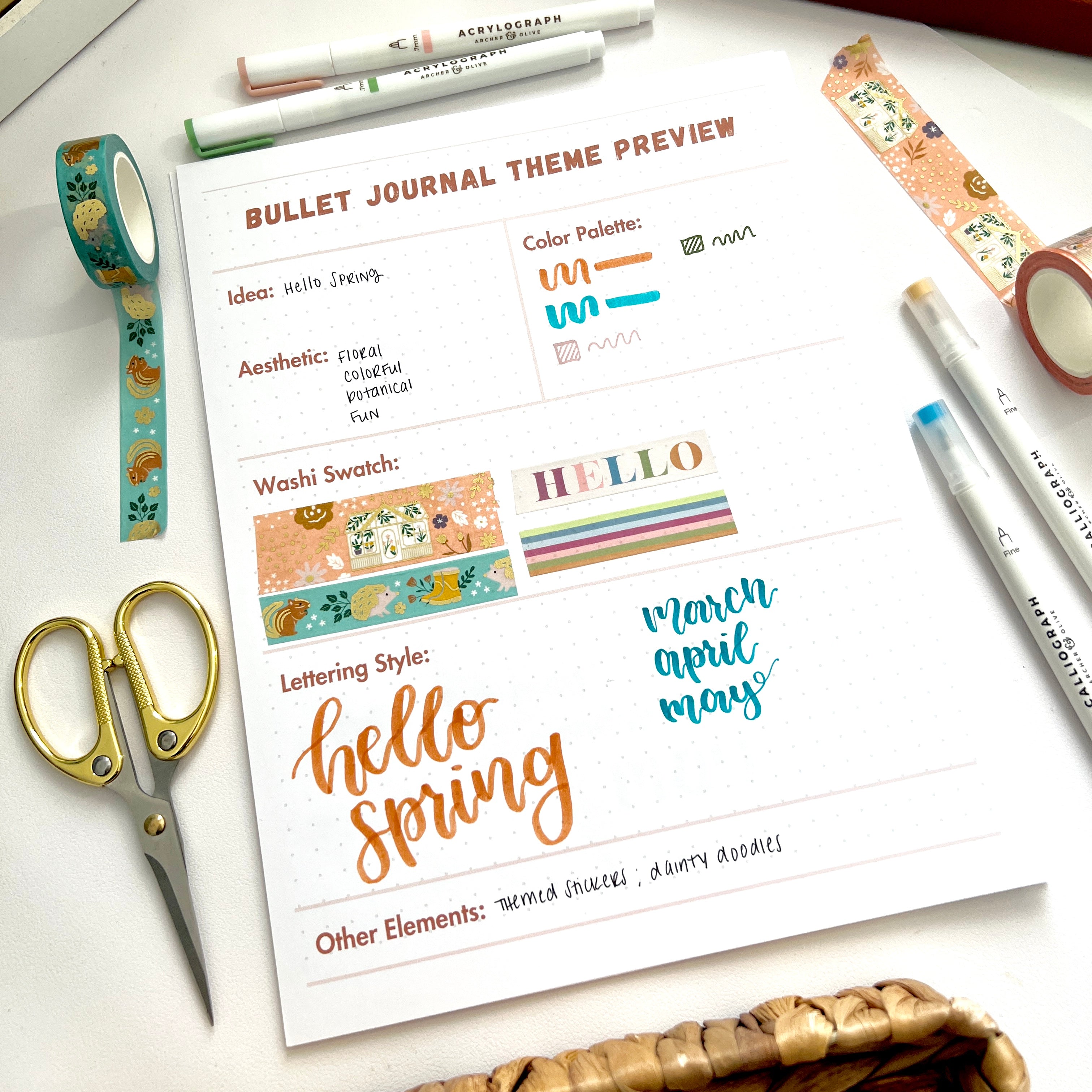 Image showing the free printable included in this blog post to create a Hello Spring bullet journal theme in a flat lay surrounded by a pair of scissors, decorative tape, and markers