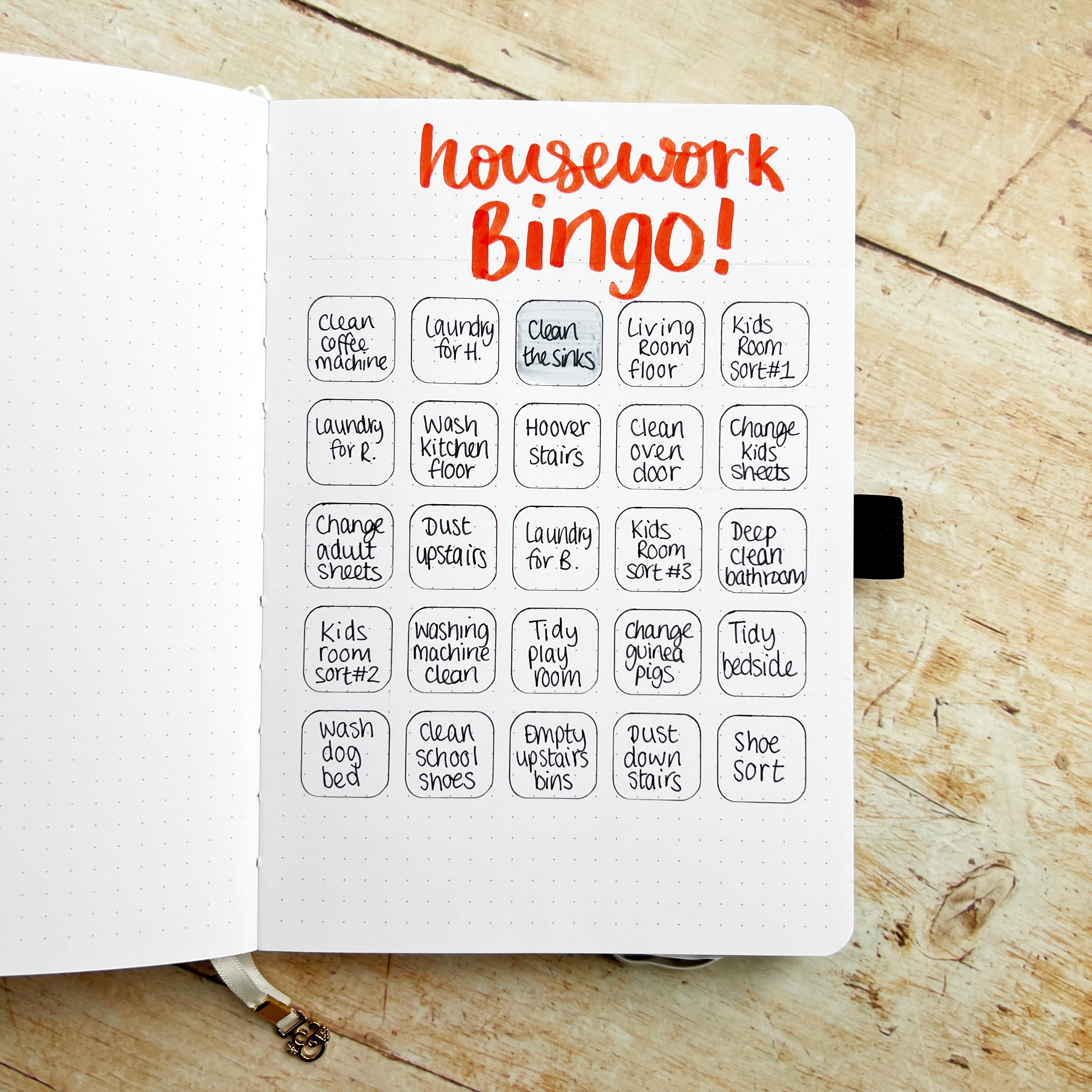 open journal with title housework bingo and tasks written into squares