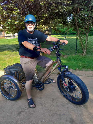 A customer is posing on his electric Fat Trike outside on his favorite trail..