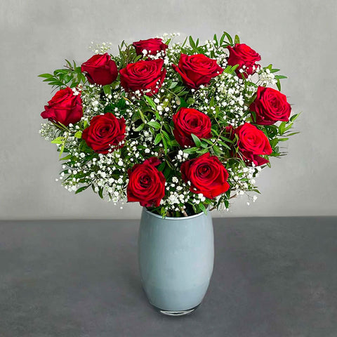 Le bouquet de roses rouges fraîches attachées à la main Douzaine d'amoureux