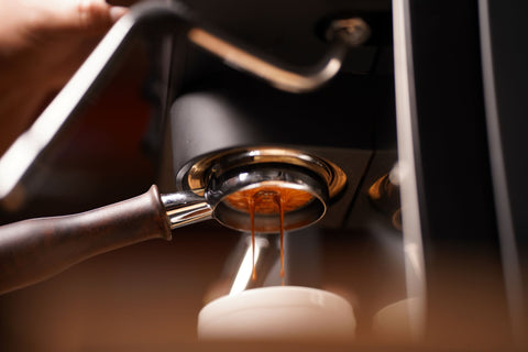 espresso shot coming out of walnut handled bottomless portafilter