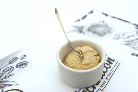 scoop of coffee ice cream in ceramic dish with silver spoon