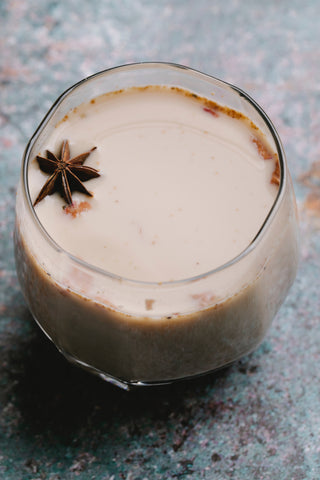 A glass of horchata with an anise star floating on top. 