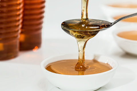 Honey cascading from a spoon into a shallow bowl.