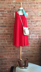 red sleeveless dress, mint kerchief, brown wedges, and cream crossbody