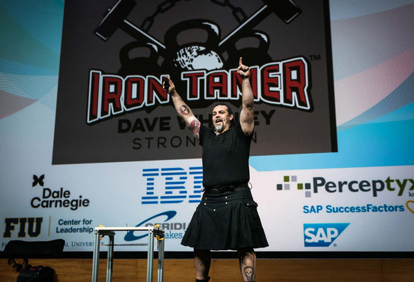strongman Iron Tamer Dave Whitley performs a feat of strength on stage