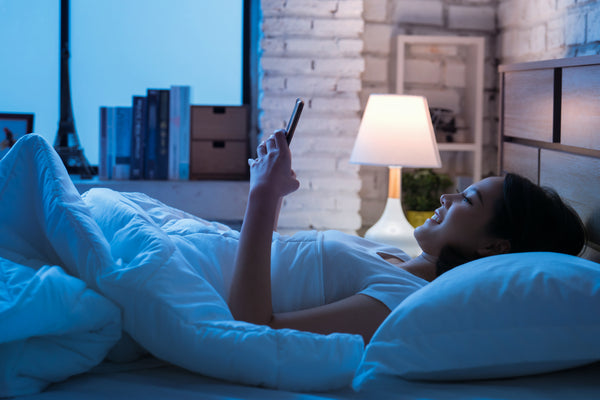 Woman using smartphone in bed