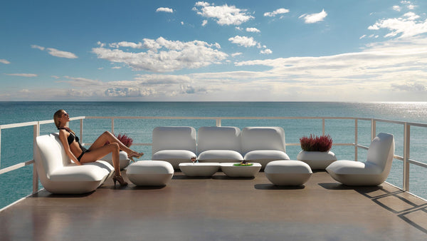 Woman enjoying the Pillow Outdoor Furniture collection by Vondom on a sunny deck by the sea